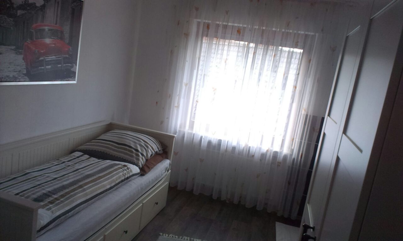 Ein Schlafzimmer mit einem Einzelbett und einem Fenster.