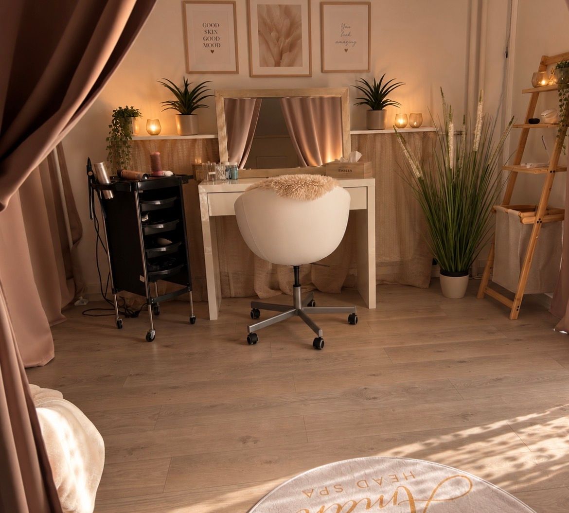 Gemütliches Schlafzimmer mit warmrosa Beleuchtung, herzförmigen Handtuchfiguren, Kerzen und dekorativer Wandbeschriftung