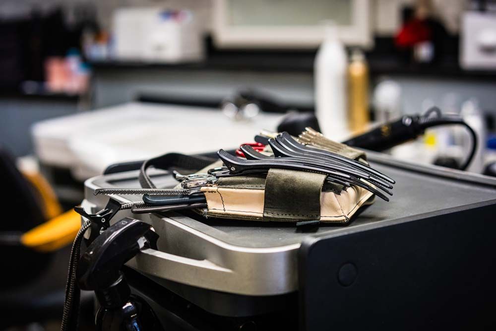 Im Friseursalon hängt über dem Waschbecken eine Uhr an der Wand.