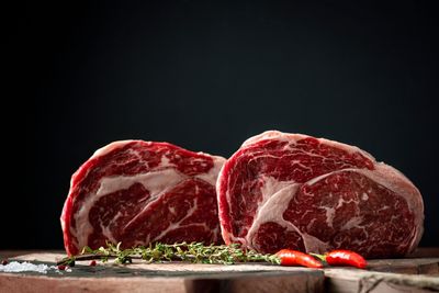 Ein Metzger schneidet rohes Rindfleisch auf einem Schneidebrett in einem Fleischereigeschäft.