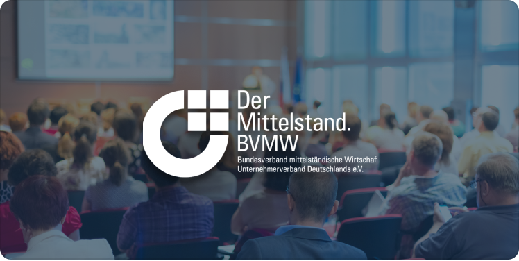 Publikum in einer Konferenzumgebung mit eingeblendetem Logo des BVMW („Der Mittelstand“).
