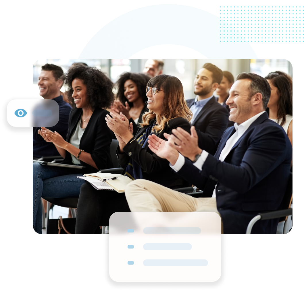 Menschen klatschen in einem Konferenzraum. Zu den lächelnden Teilnehmern gehören Männer und Frauen unterschiedlicher Herkunft in einer hellen Umgebung.