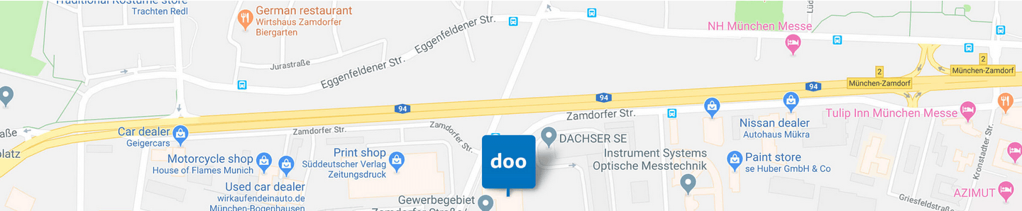 Weitwinklige Kartenansicht mit einer blauen Standortmarkierung und mehreren orangefarbenen und blauen Ortsmarkierungen entlang einer Straße.
