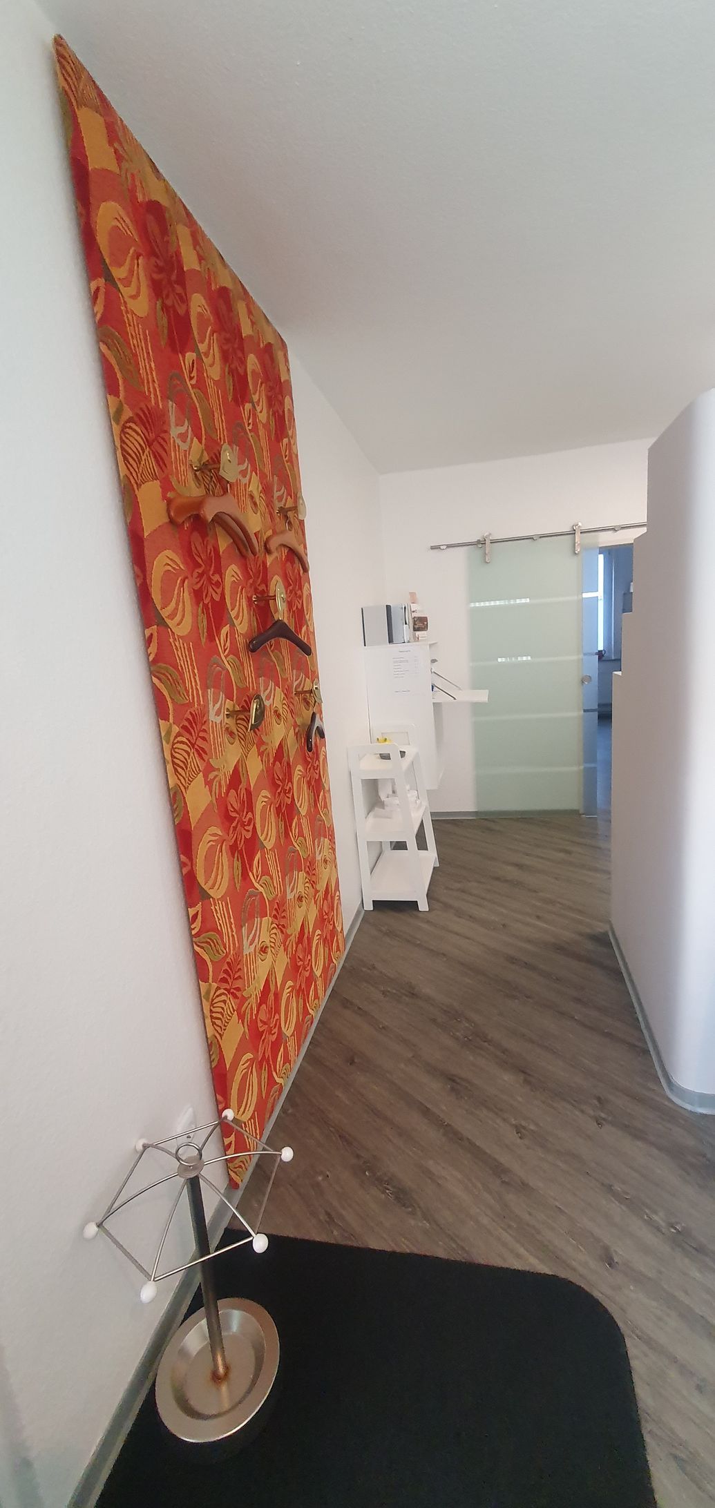 ein Flur mit einer roten Wand und einer schwarzen Decke