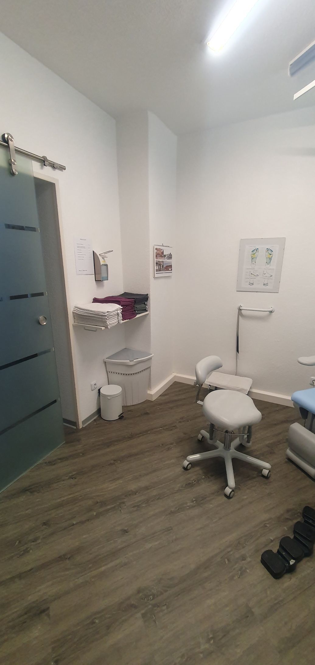 ein kleiner Raum mit Holzboden und weißen Wänden