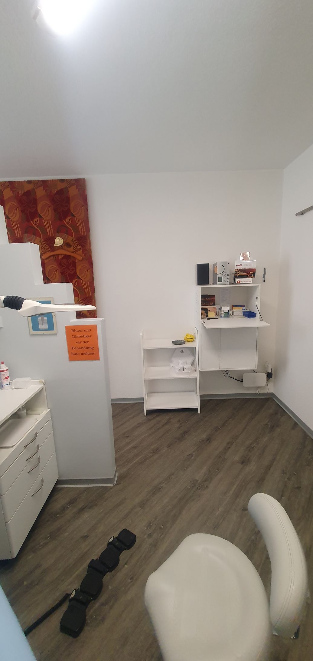 ein Raum mit einem Stuhl , einem Regal und einem Kühlschrank