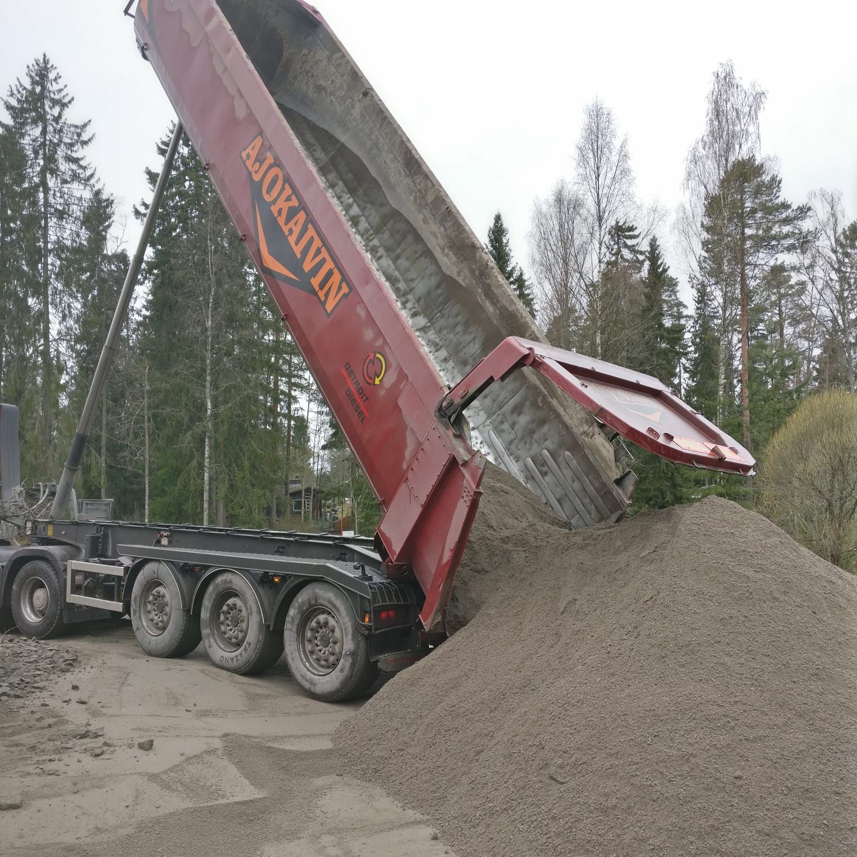 Kippiauto purkaa soraa metsäisellä ulkoalueella