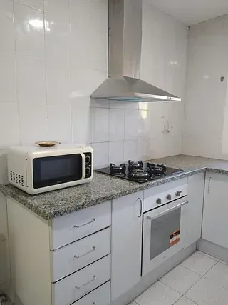 Una cocina con estufa, microondas y horno.