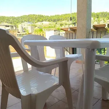 Una mesa y sillas en un balcón con vista a las montañas.