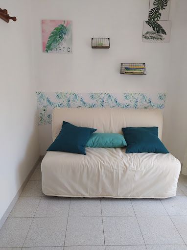 Un sofá blanco con almohadas azules en una sala de estar.