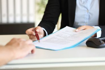 eine Person im Anzug trägt Akten im Arm