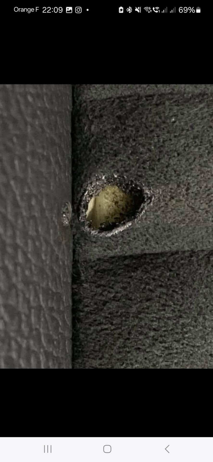 Une vue rapprochée montre une surface en cuir noir à côté d'un matériau texturé sombre avec un trou.