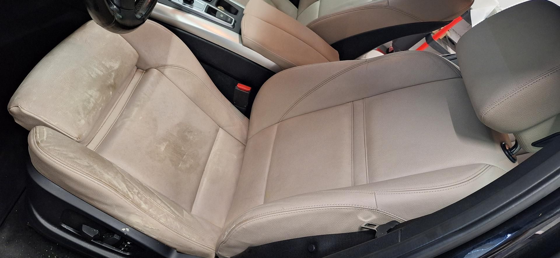 Siège auto beige avec taches et usures visibles.