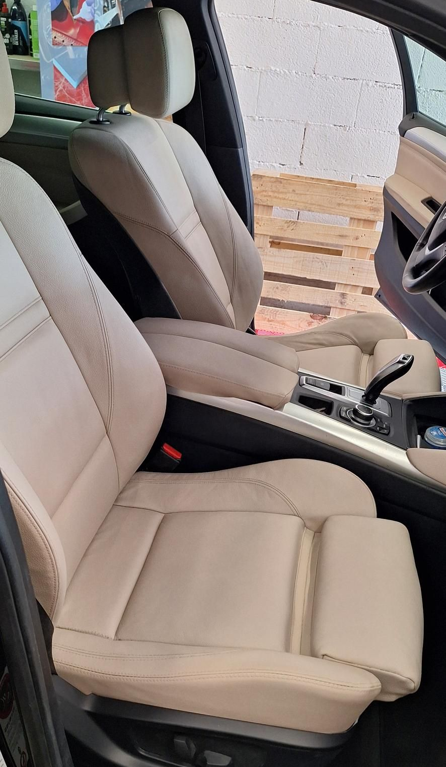 Sièges de voiture en cuir beige, portière de voiture ouverte, vue intérieure.