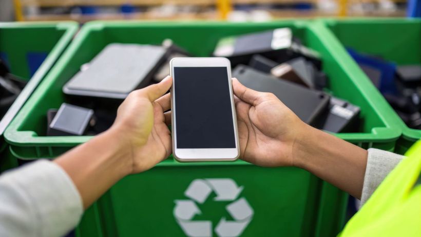Smartphone au dessus d'un bac de tri