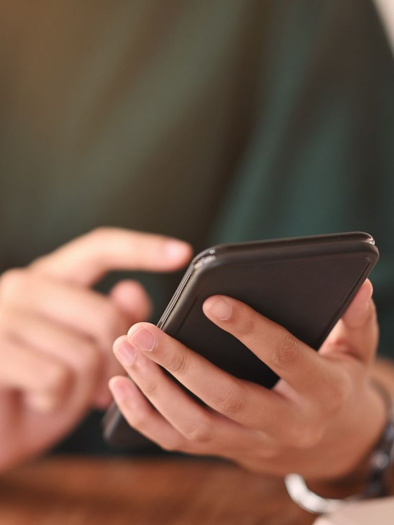 Smartphone noir tenu par une main