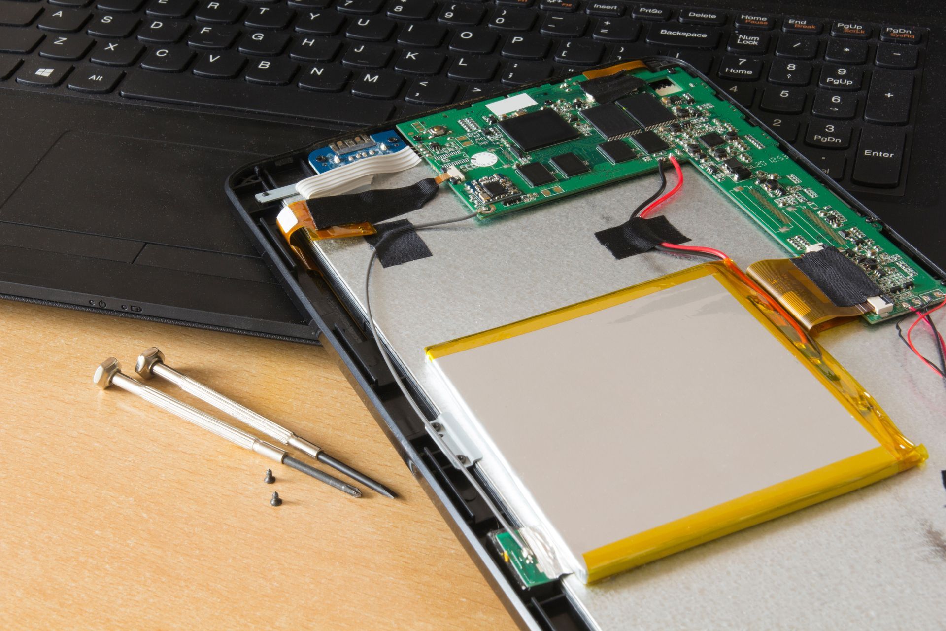 Tablette en cours de réparation près d'un PC