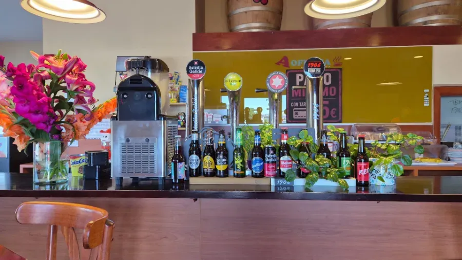 Barra con grifos de cerveza, botellas, flores y cálidas lámparas colgantes en un restaurante acogedor.