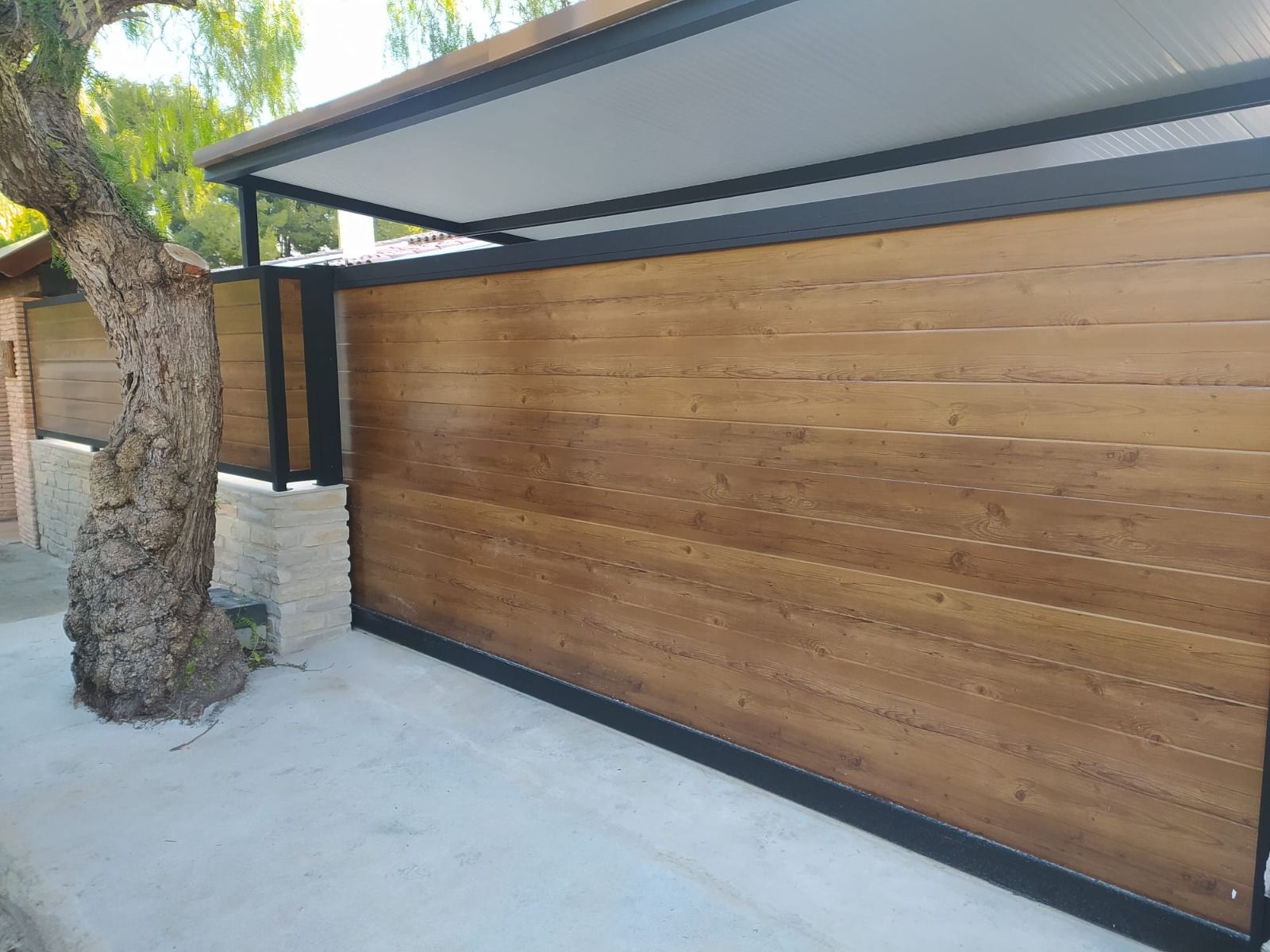 Puertas dobles de cristal con marco de madera y paneles azules, integradas en una pared de ladrillo.