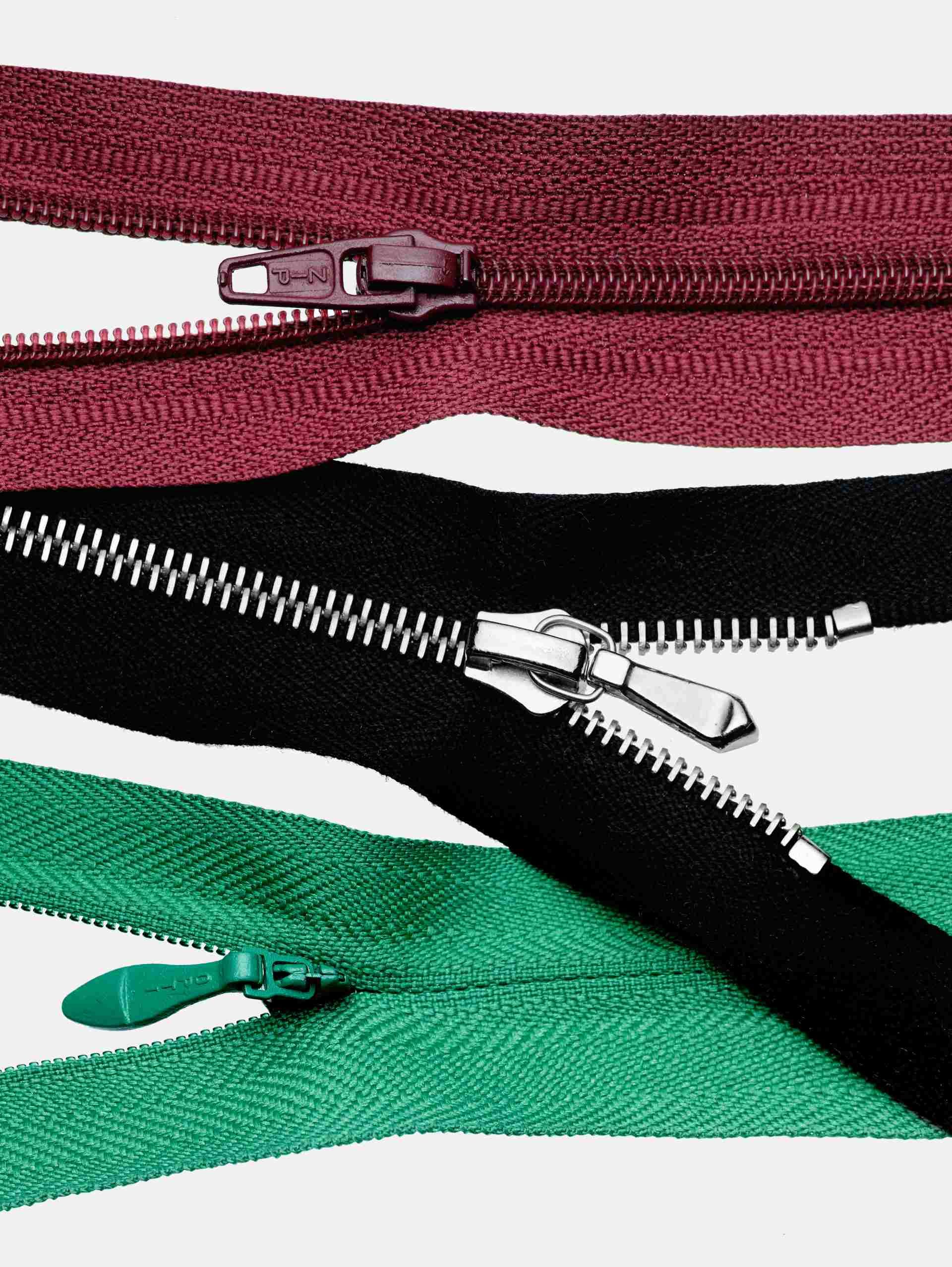 Tre cerniere color marrone, nero e verde sono disposte verticalmente su uno sfondo bianco.