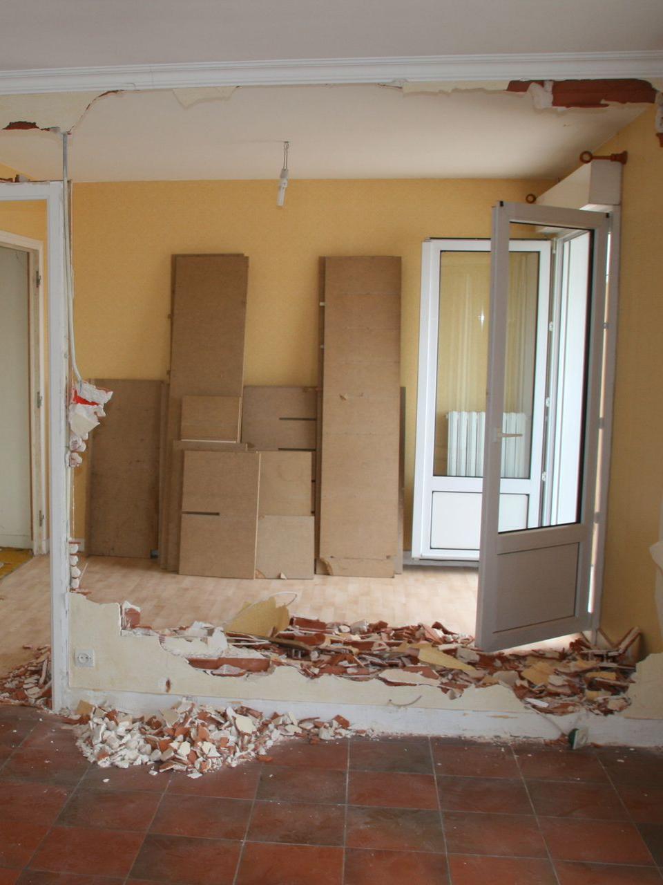 Un mur démoli avec des matériaux posés sur le mur en arrière plan