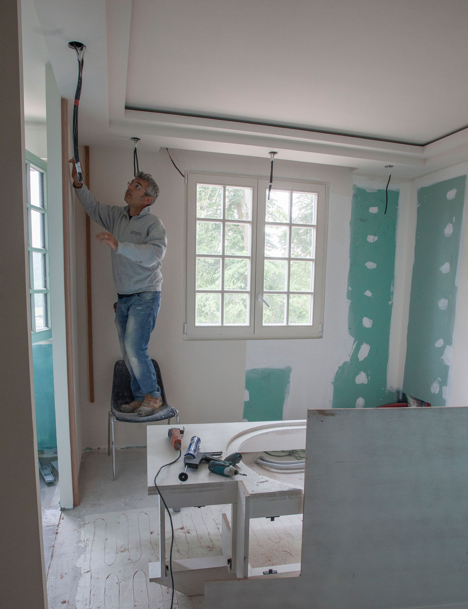 Un monsieur peint les murs intérieurs d'un logement