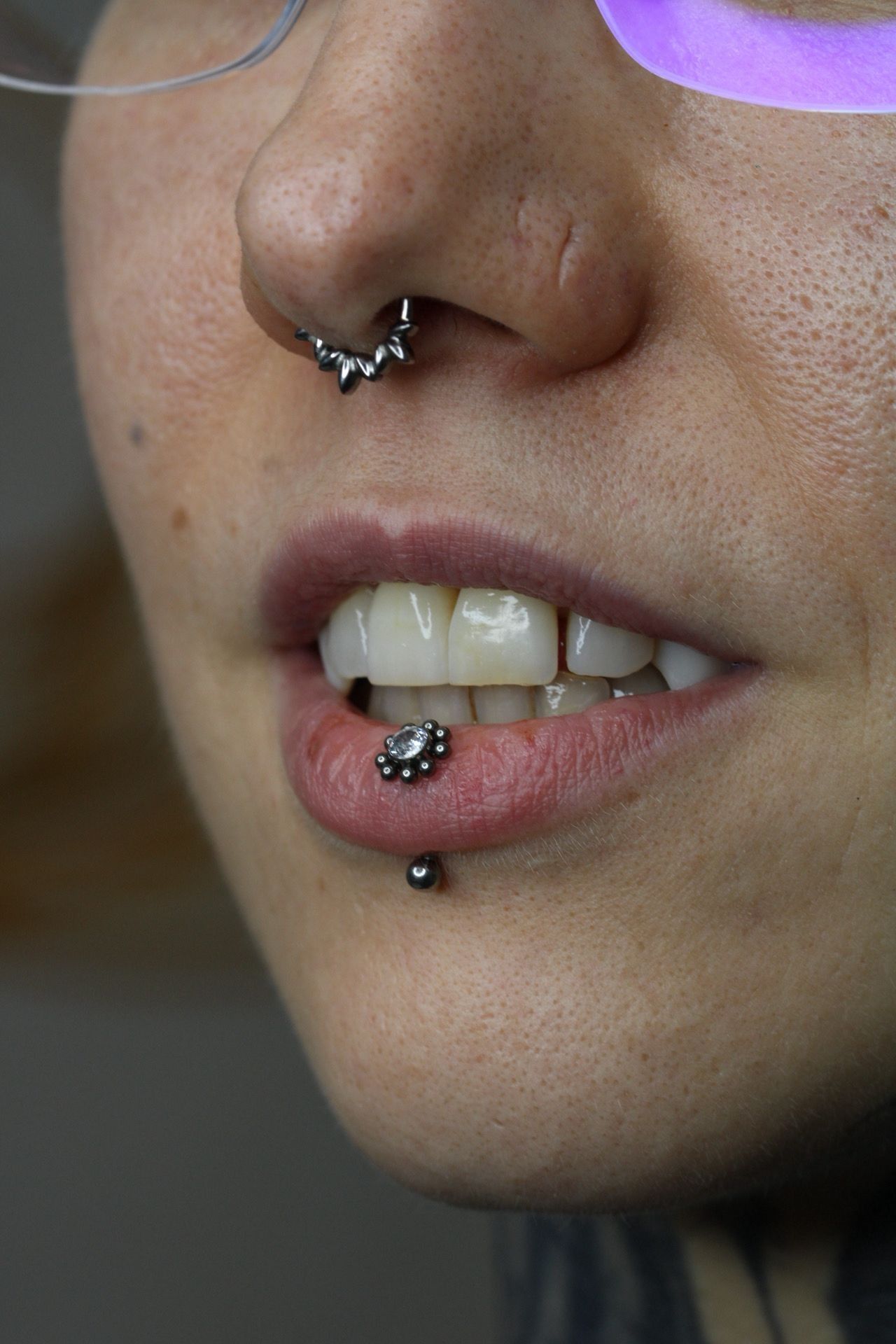 Primer plano de un rostro con piercings en la nariz y los labios