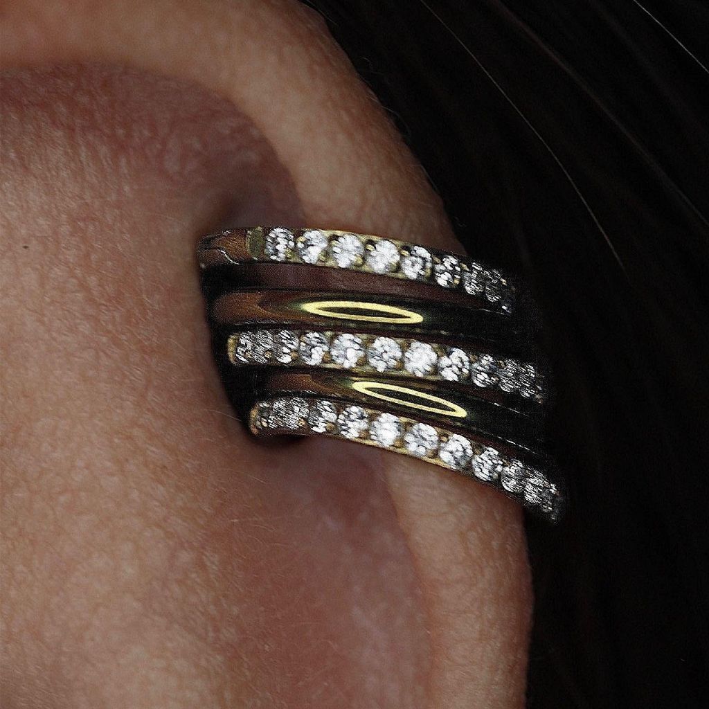 Primer plano de un pendiente de oreja con incrustaciones de diamantes en la oreja de una persona.