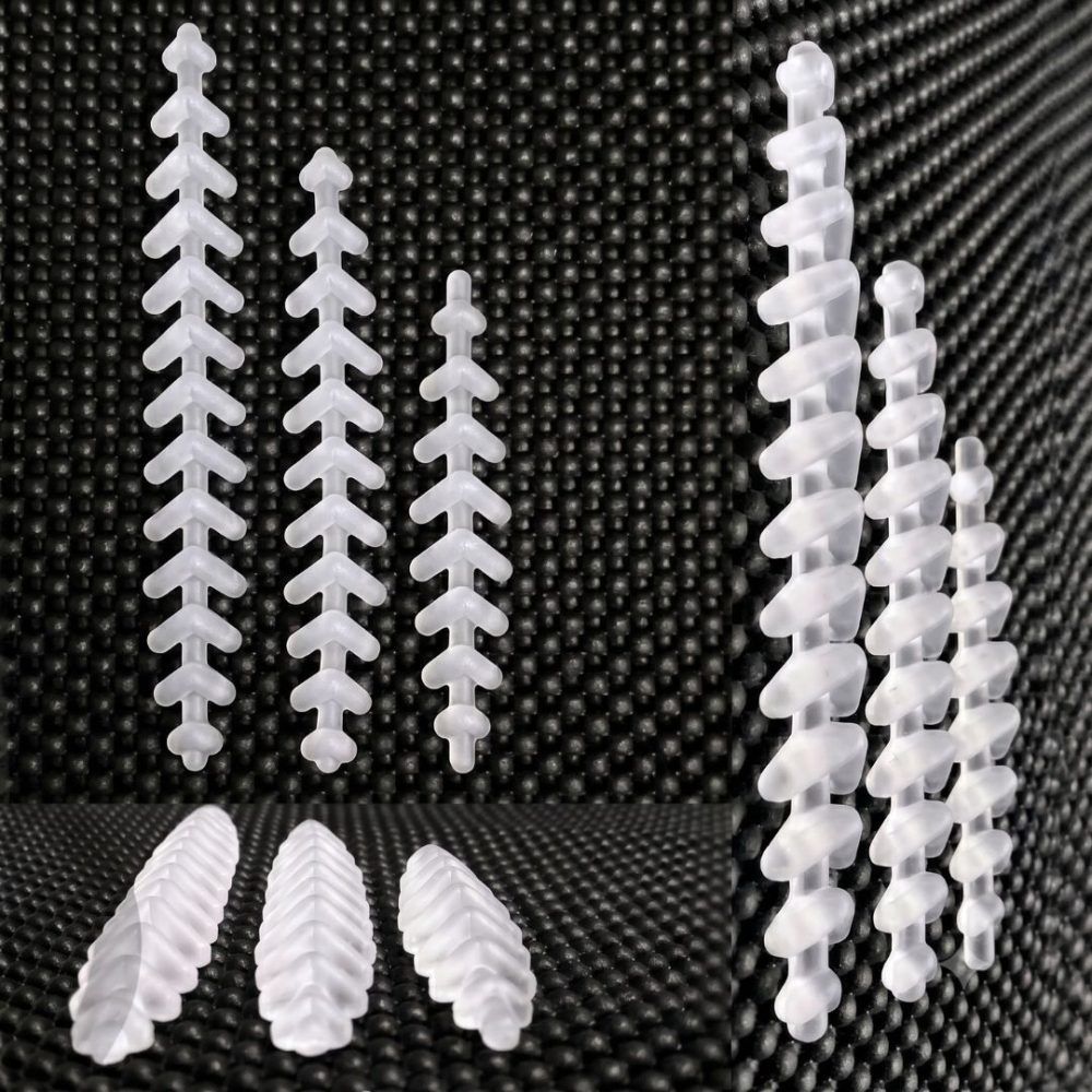 Sujeta-sujetadores y clips de plástico blanco surtidos dispuestos sobre un fondo negro texturizado.
