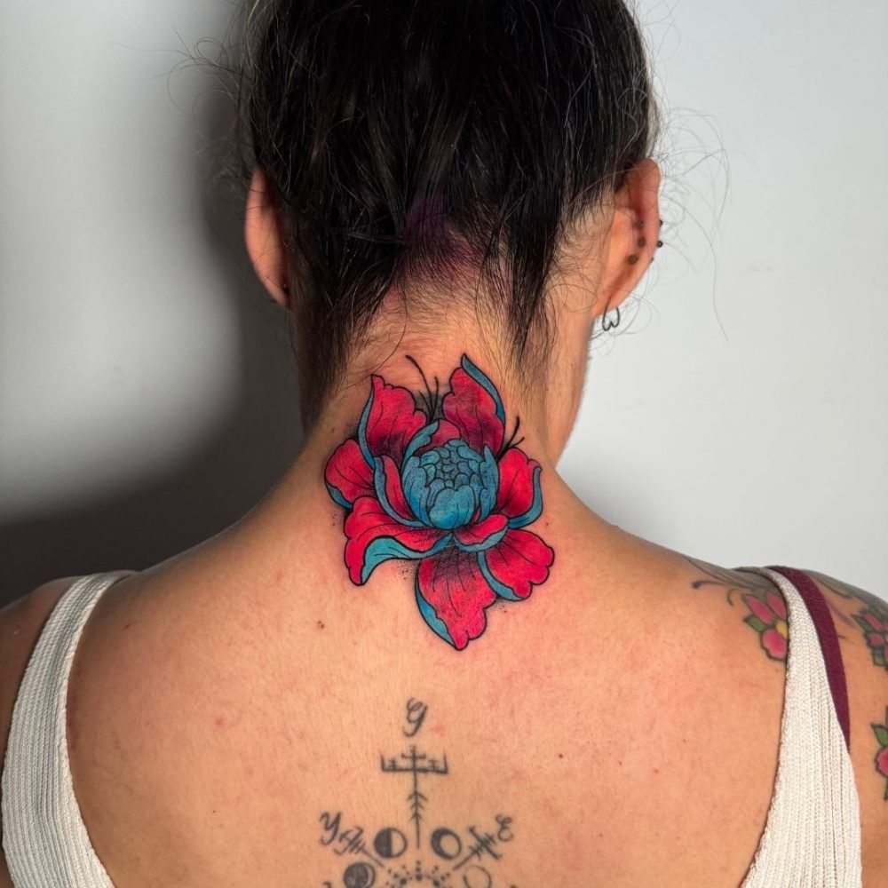 En la nuca tiene un llamativo tatuaje de una flor roja y azul y un pequeño tatuaje de un símbolo negro debajo.