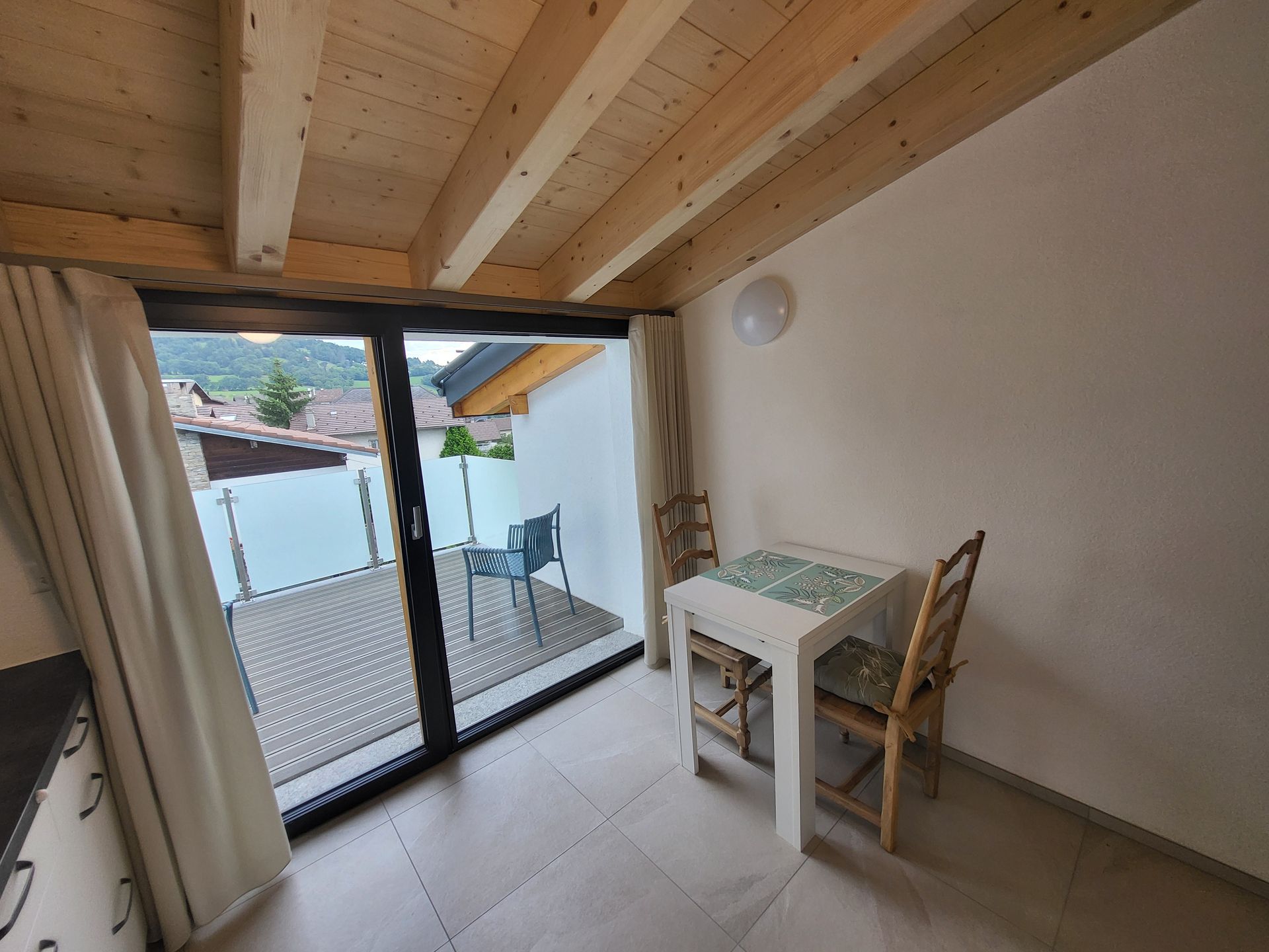Une pièce avec une table et des chaises et un balcon