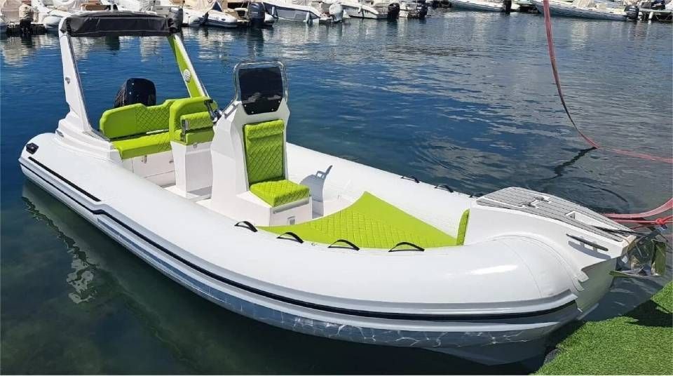 Motoscafo gonfiabile bianco con sedili verde lime ormeggiato su acque calme in un porto turistico