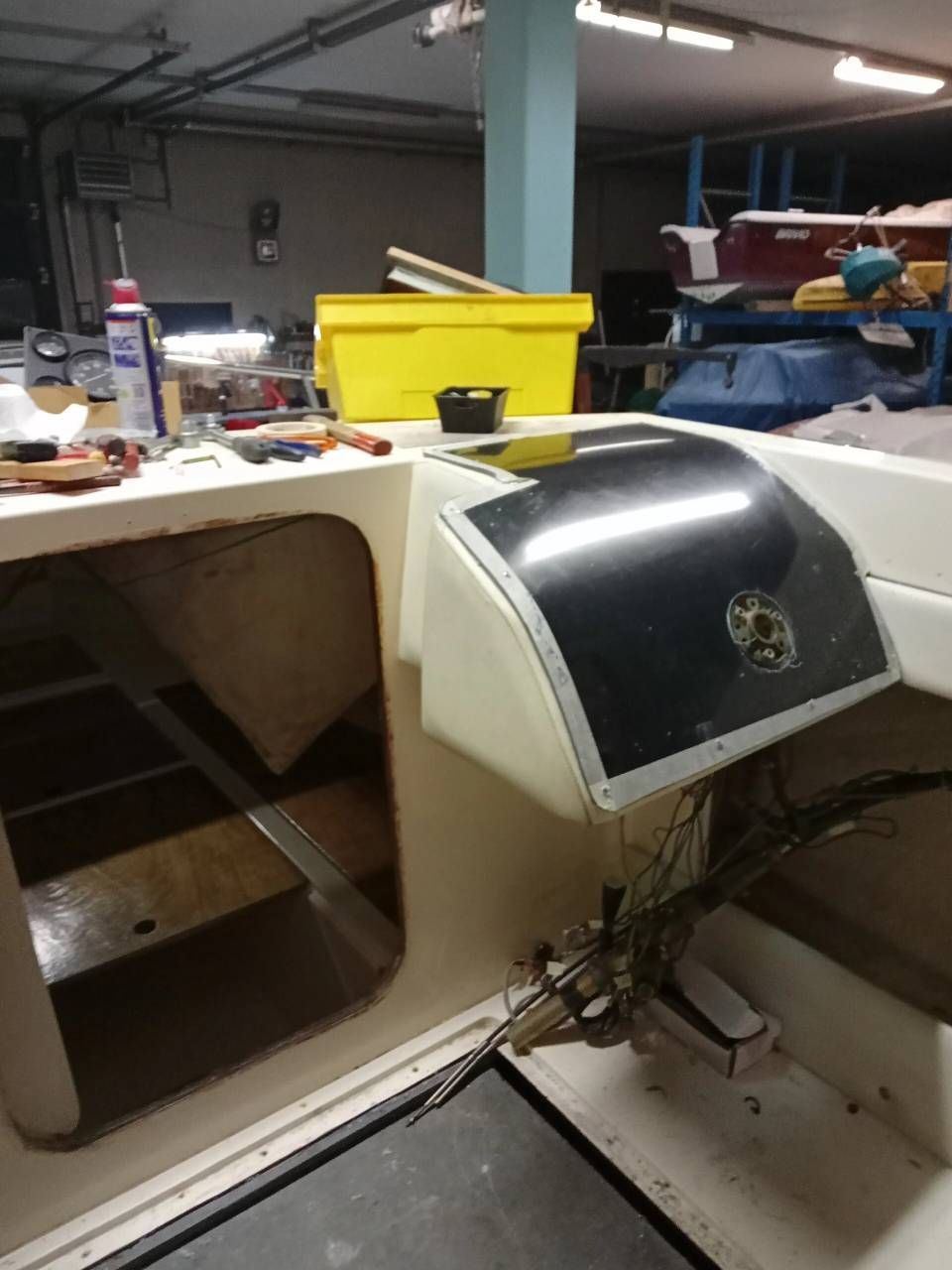 Tavolo da officina con una macchina da cucire in bianco e nero e attrezzi su un banco da lavoro ingombro.