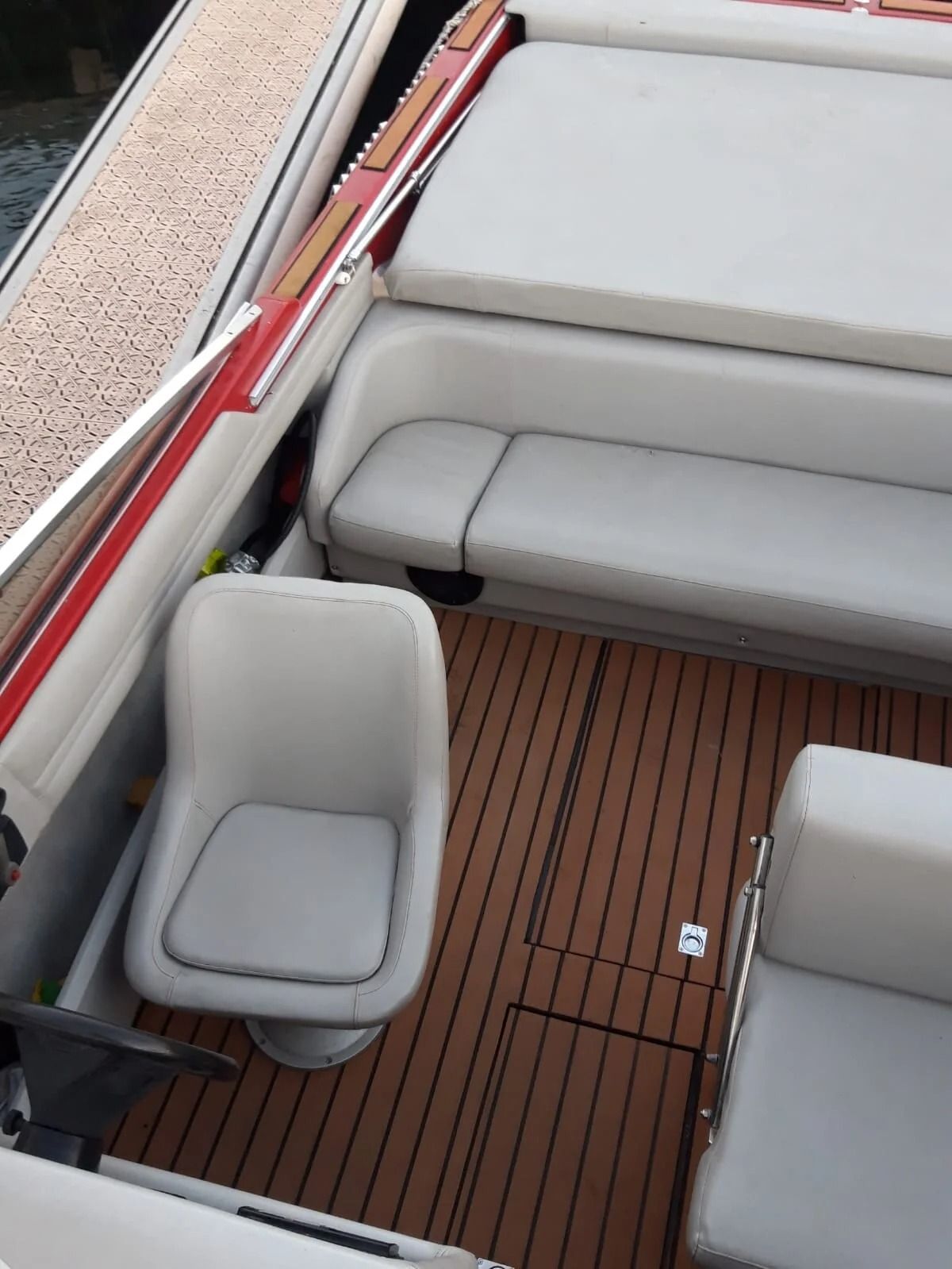 Ti Yachts Sagl
Ponte della barca con panche imbottite grigie, ringhiere laterali bianche e pavimento in teak.