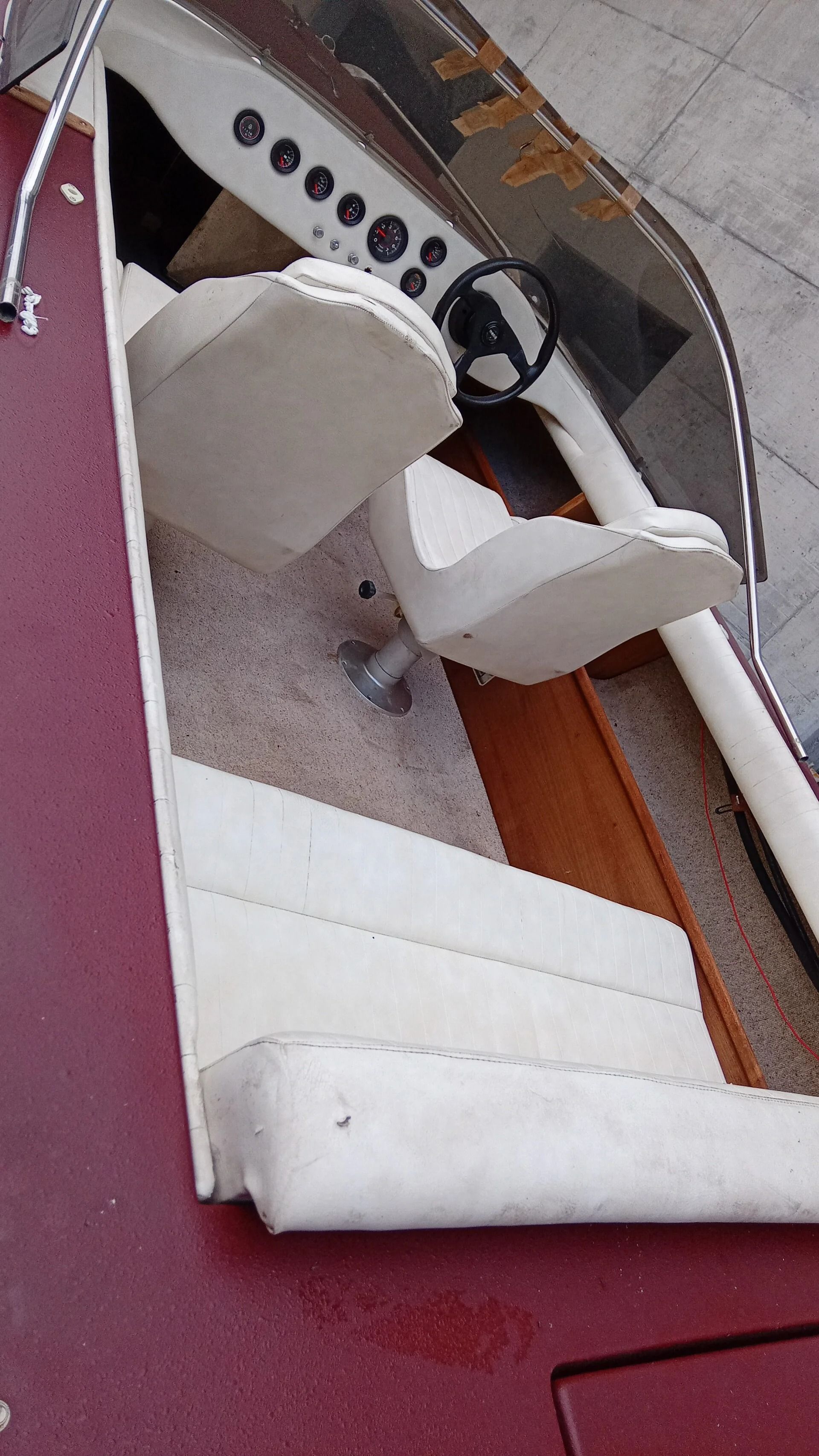 Ti Yachts Sagl
Primo piano dei sedili di una barca rivestiti in tessuto bianco e degli interni della cabina con finiture del pavimento rosse.