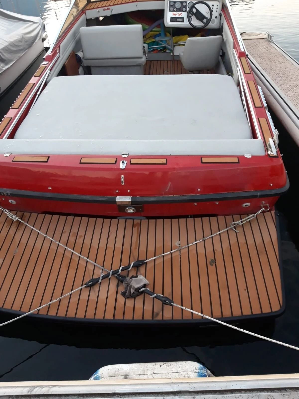 Ti Yachts Sagl
Motoscafo rosso e bianco ormeggiato a un molo di legno, visto da poppa.