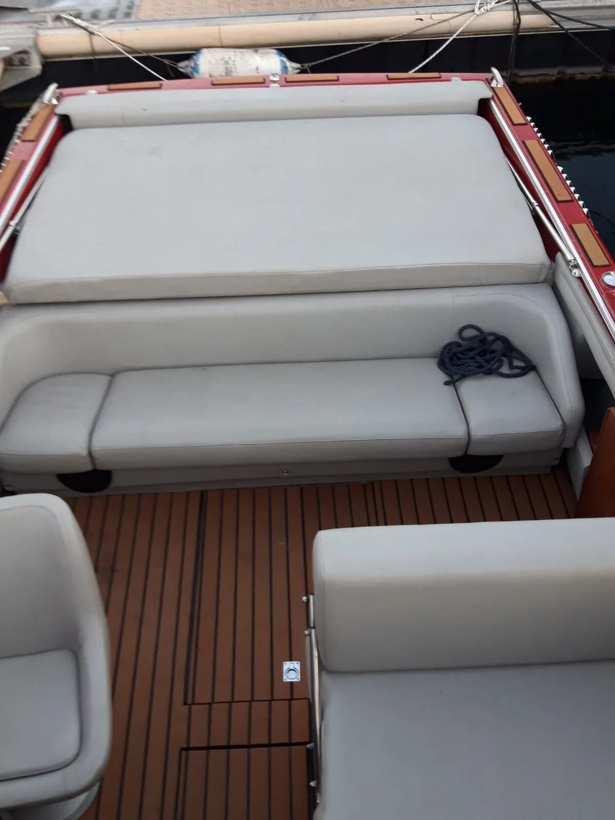 Ti Yachts Sagl
Ponte della barca con sedute imbottite bianche e pavimento in teak, visto dall'alto.