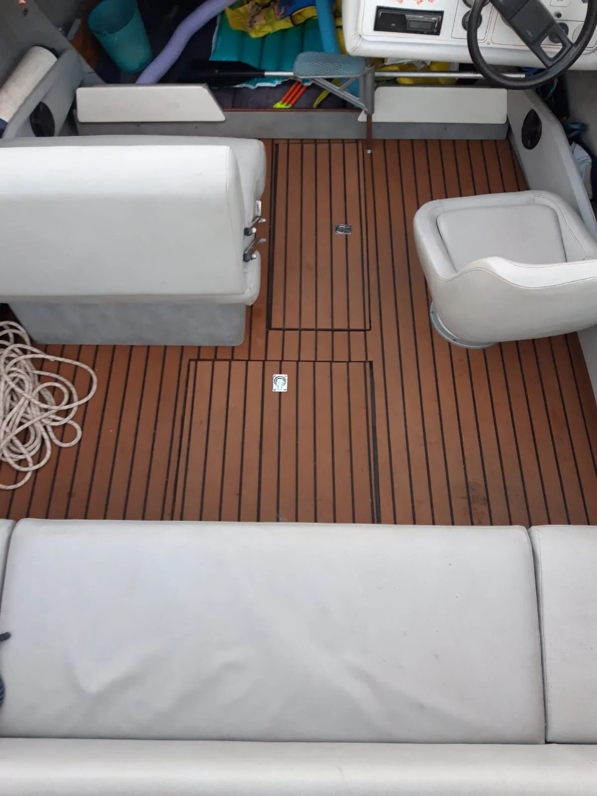 Ti Yachts Sagl
Abitacolo di una barca con cuscini bianchi e ponte in teak, visto dall'alto.