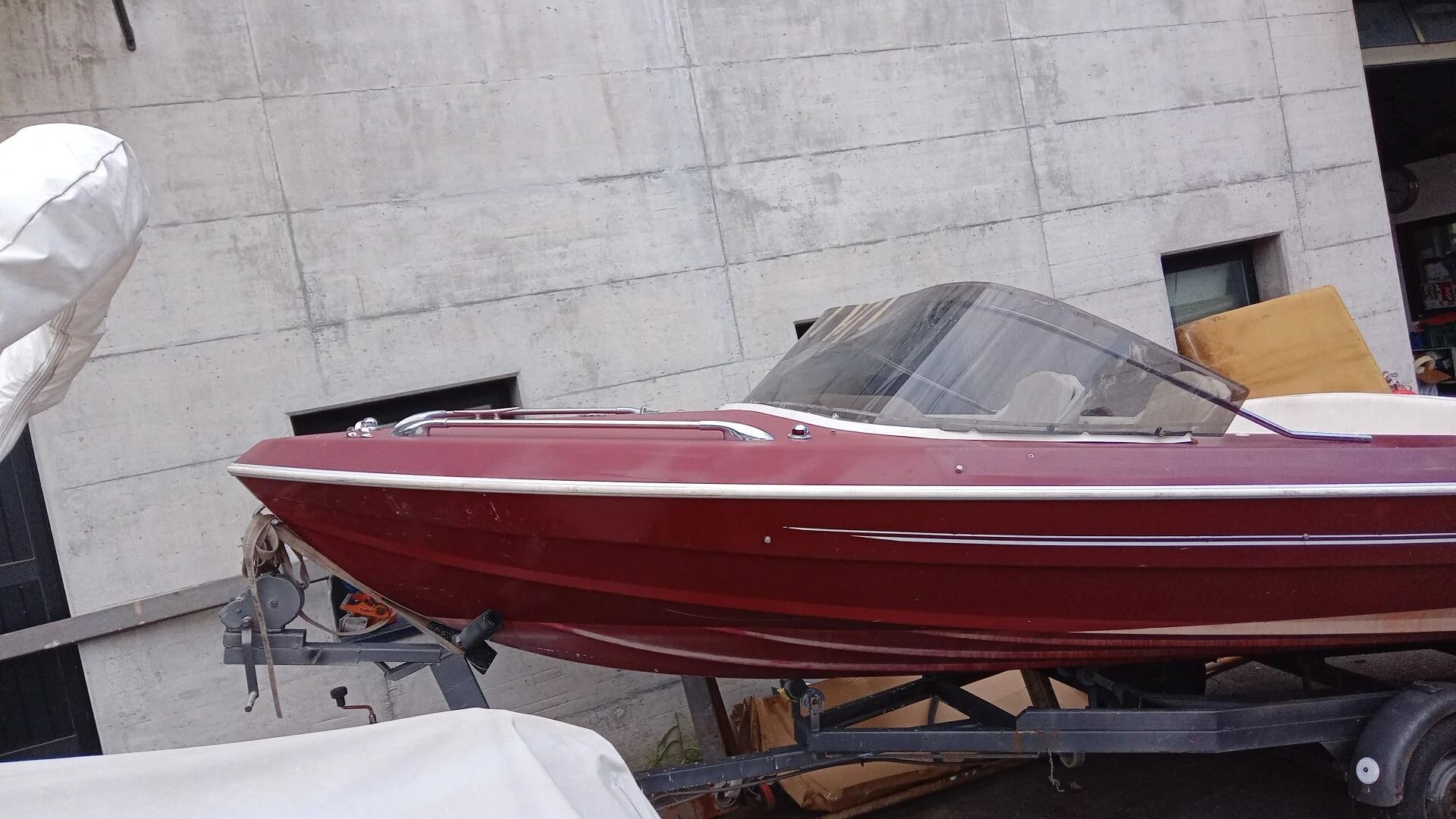 Ti Yachts Sagl
Motoscafo rosso su rimorchio, parcheggiato accanto a un muro bianco all'interno.