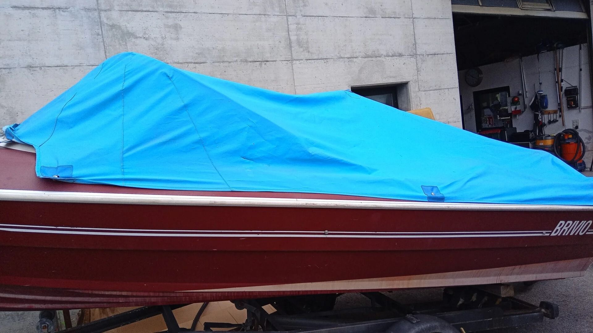Ti Yachts Sagl
Motoscafo color bordeaux coperto da un telone blu brillante in un garage