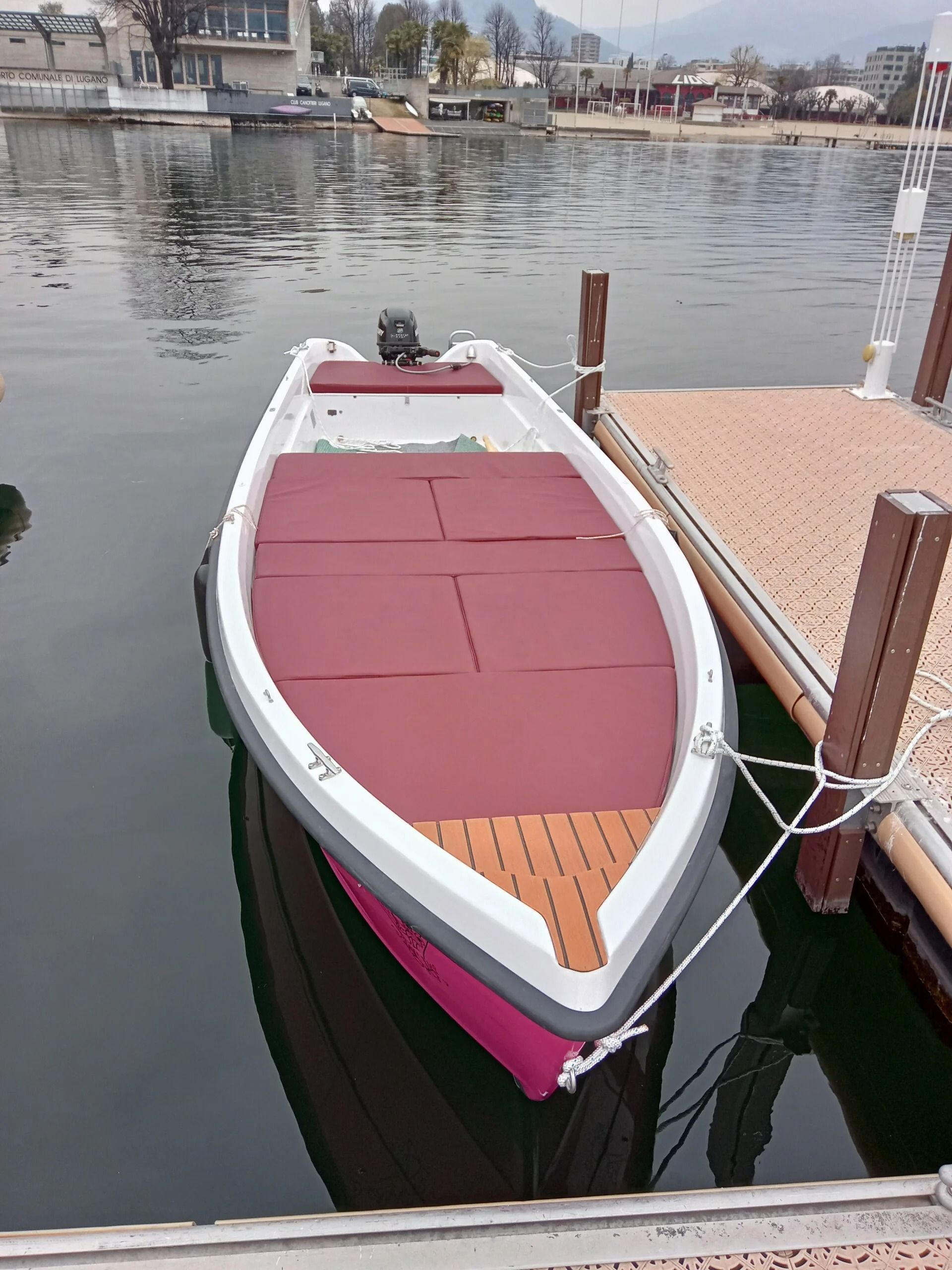 Ti Yachts Sagl 
Piccola imbarcazione rossa e bianca ormeggiata a un molo su acque calme in un porto turistico