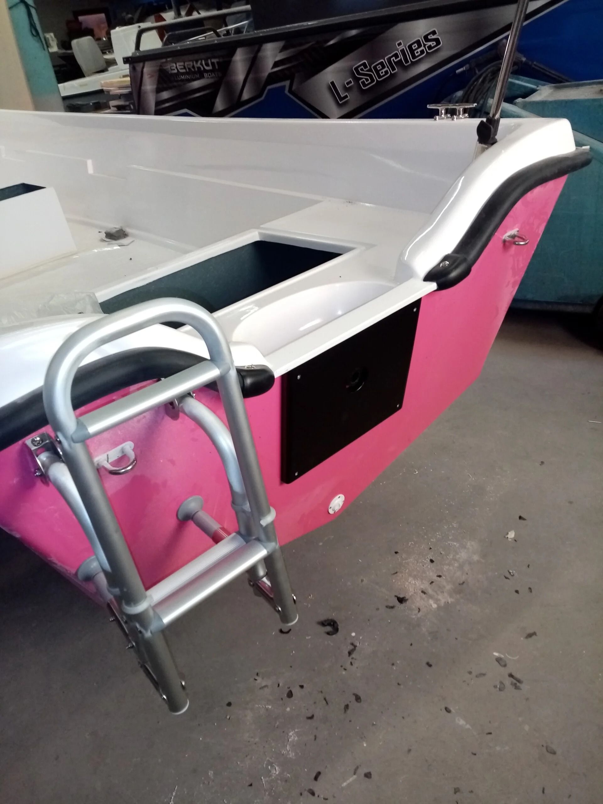 Poppa di barca rosa e bianca con scaletta in metallo, all'interno su un pavimento di cemento. Ti Yachts Sagl 
