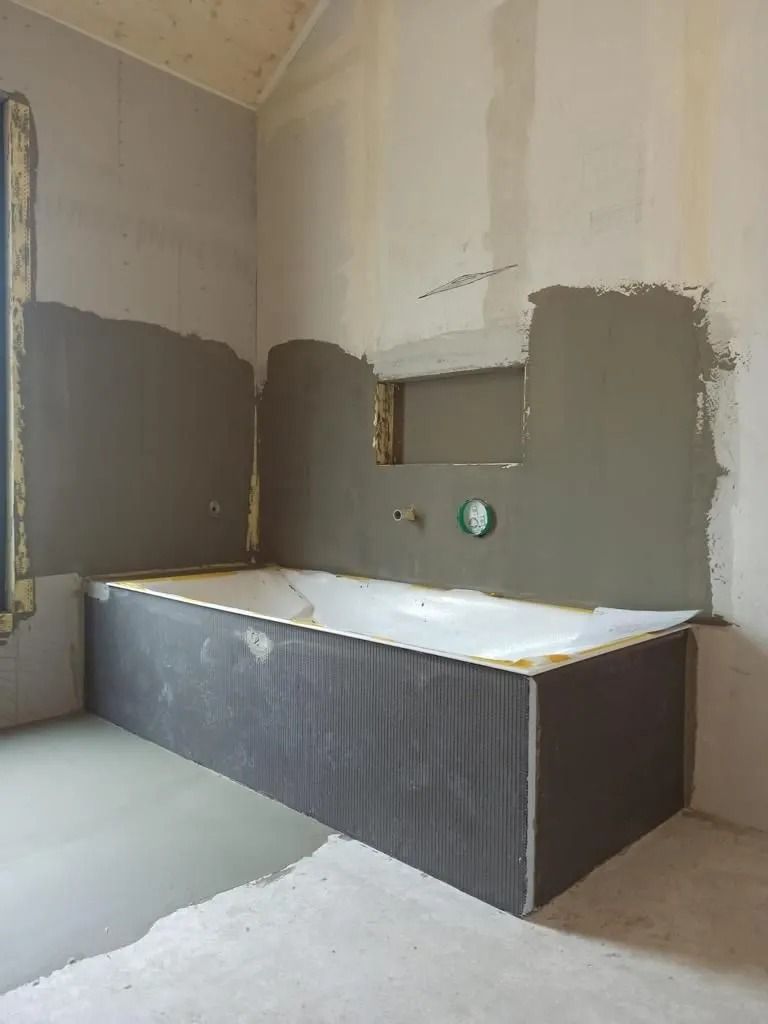 Une baignoire se trouve dans une salle de bain en construction.