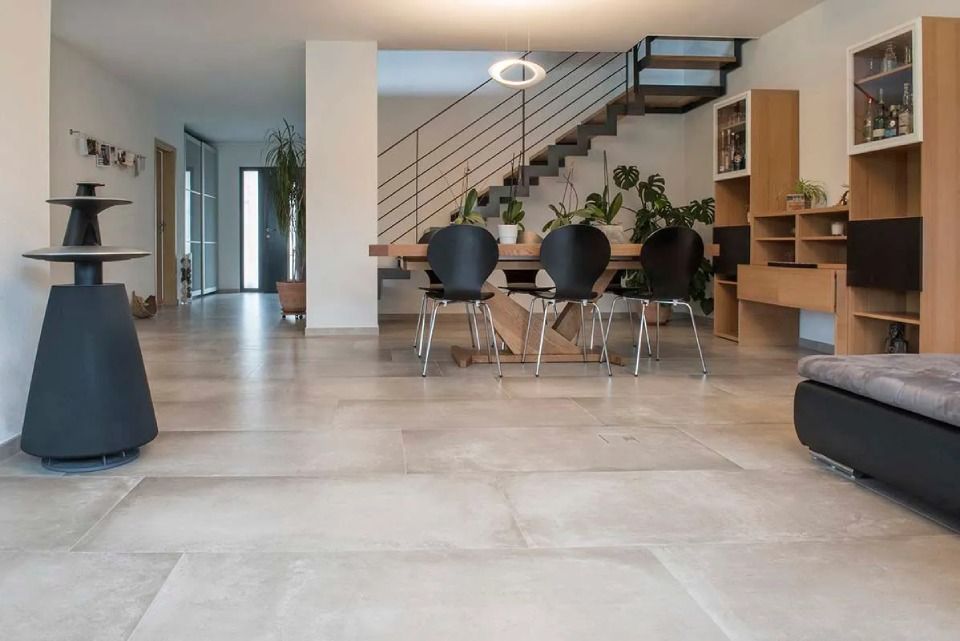 Un salon avec une table à manger et des chaises et un escalier en arrière-plan.