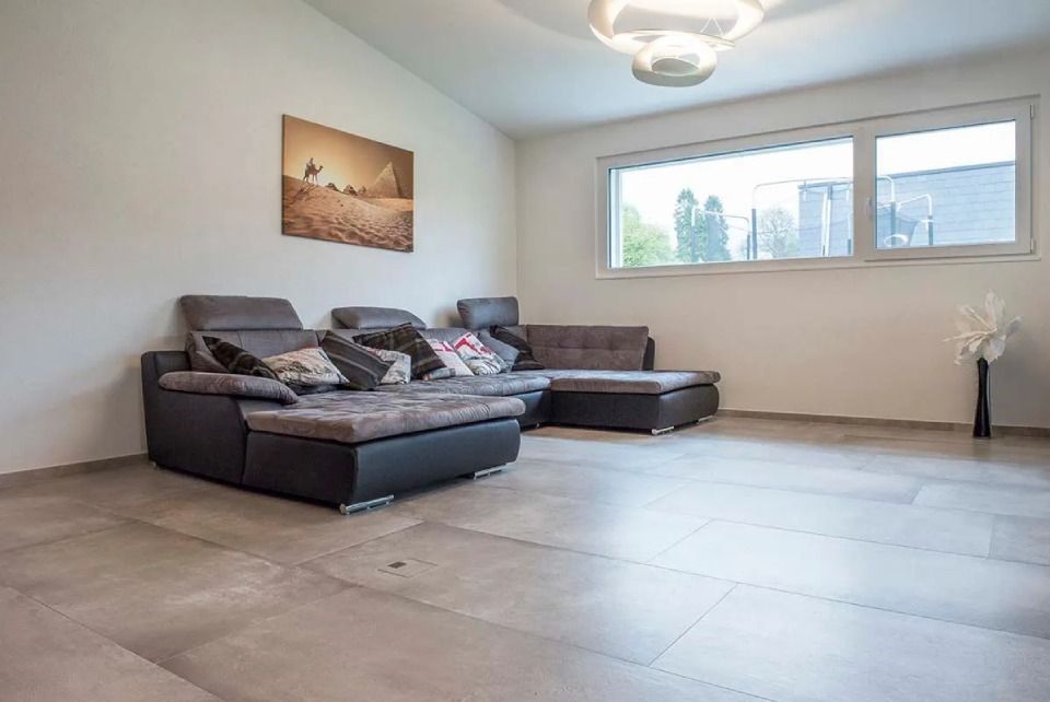 Un salon avec un canapé et une grande fenêtre.