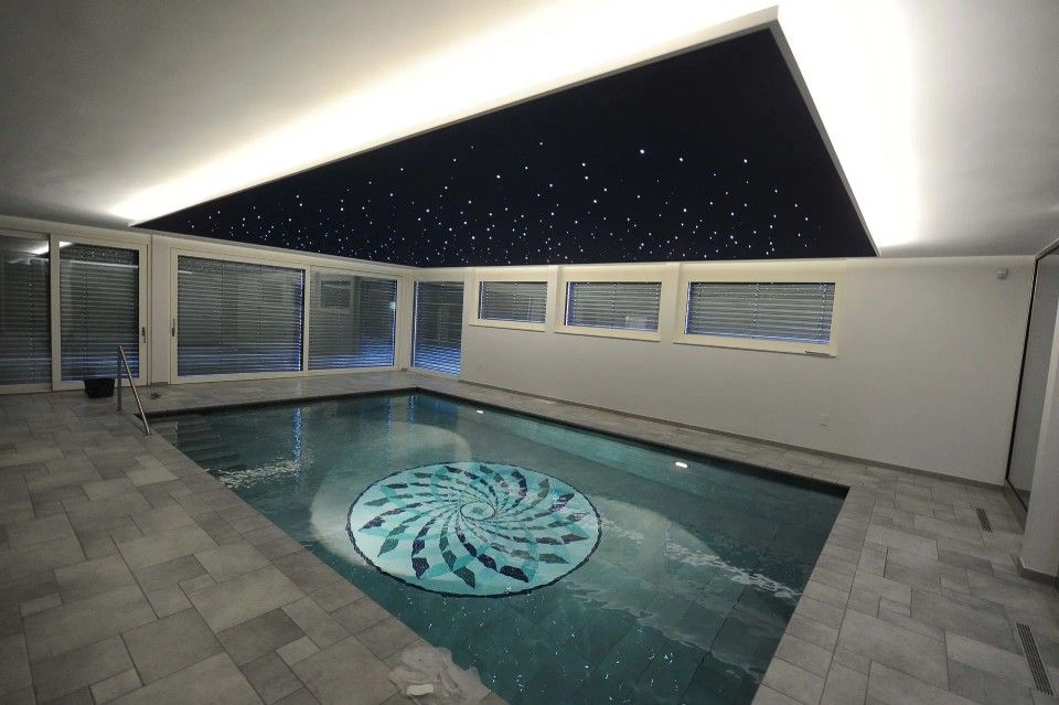 Une grande piscine intérieure avec un ciel étoilé au-dessus