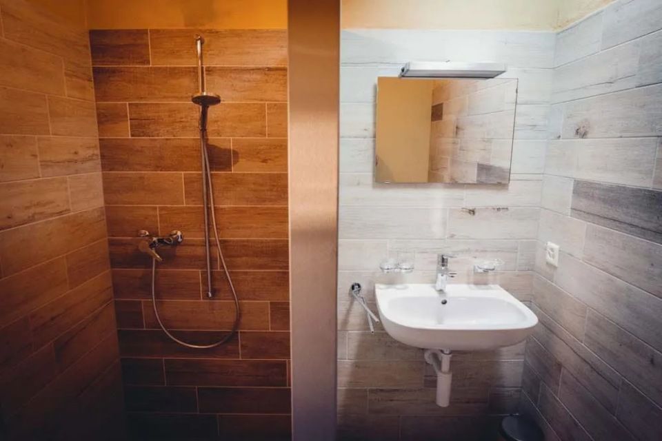 Une salle de bain avec lavabo, douche et miroir.