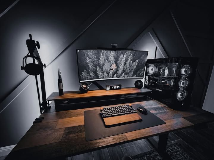 Bureau élégant pour la maison avec écran, clavier, PC de jeu et microphone dans un environnement sombre et moderne.