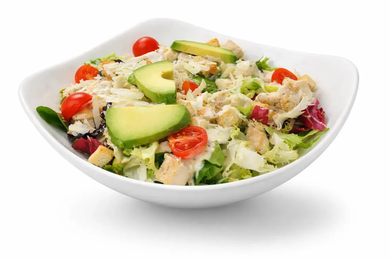 Ensalada con rodajas de aguacate, tomates cherry, hojas verdes y verduras ralladas.