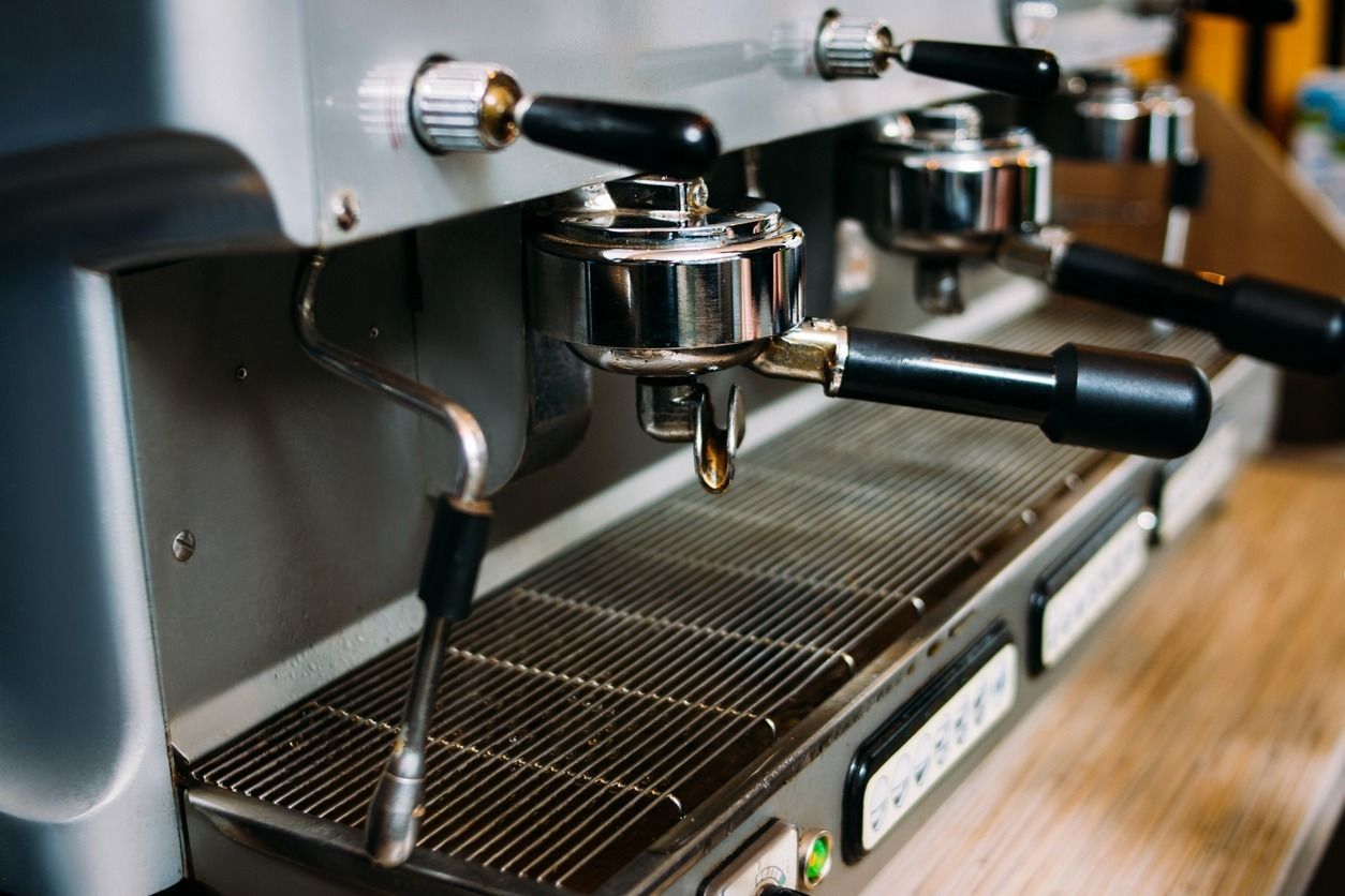 Un primer plano de una máquina de café sobre una mesa de madera.